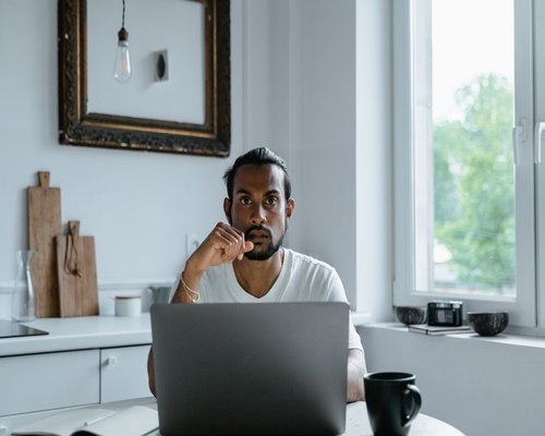 person working on a laptop in a bright Indian home